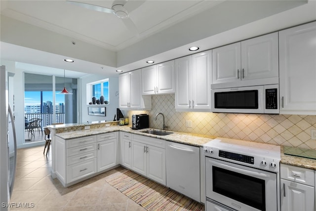 kitchen with sink, stainless steel appliances, kitchen peninsula, decorative light fixtures, and white cabinets