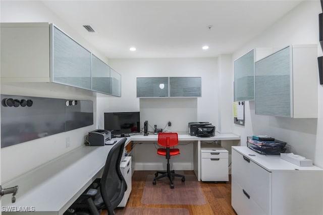 office featuring built in desk and dark hardwood / wood-style floors