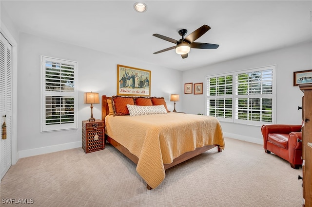 bedroom featuring light carpet, a closet, and ceiling fan