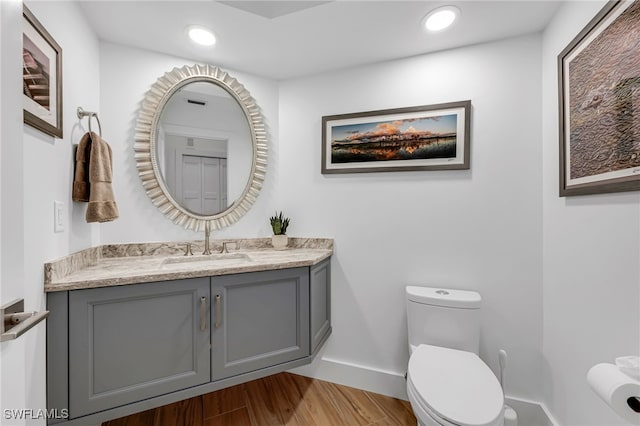 bathroom with hardwood / wood-style floors, vanity, and toilet