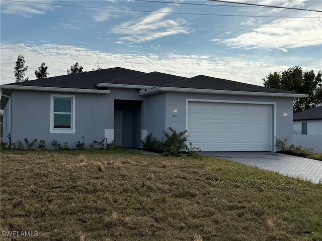 single story home with a front yard and a garage