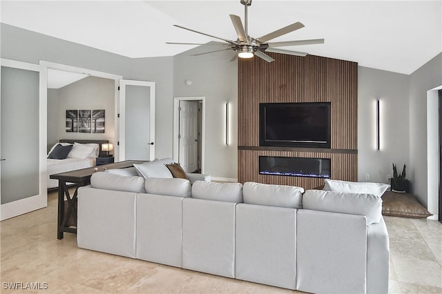 living room featuring ceiling fan, lofted ceiling, and a fireplace