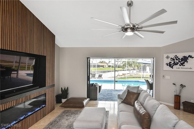 living room featuring ceiling fan and a large fireplace