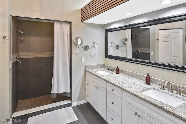 bathroom featuring vanity, a tile shower, and tile patterned flooring