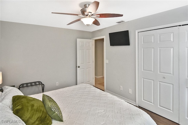 bedroom featuring ceiling fan, a closet, and dark hardwood / wood-style flooring