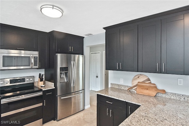 kitchen with stainless steel appliances and light stone counters