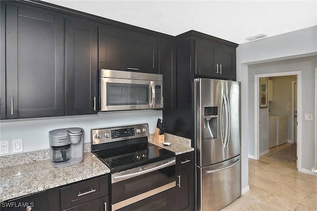 kitchen with light stone counters, separate washer and dryer, and appliances with stainless steel finishes