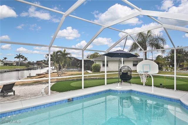 view of pool featuring glass enclosure, a patio area, and a water view