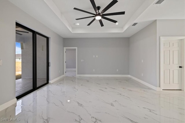 unfurnished room featuring ceiling fan and a tray ceiling