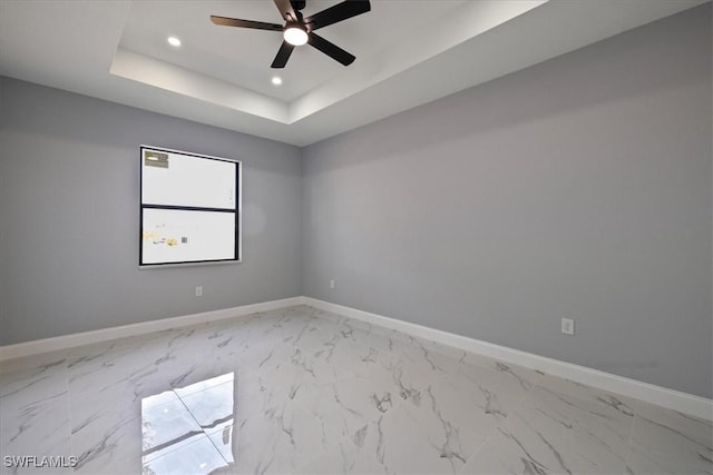 spare room featuring ceiling fan and a tray ceiling