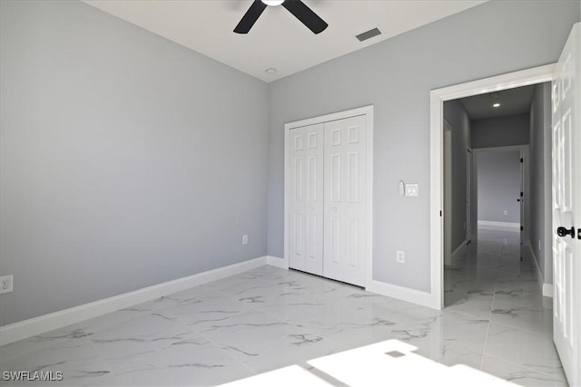 unfurnished bedroom featuring ceiling fan and a closet