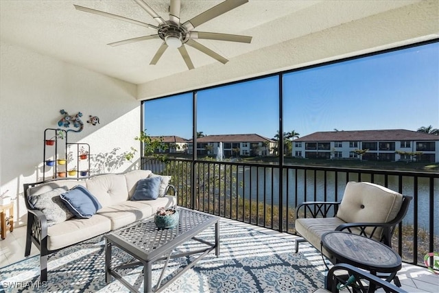 sunroom / solarium with a water view and ceiling fan