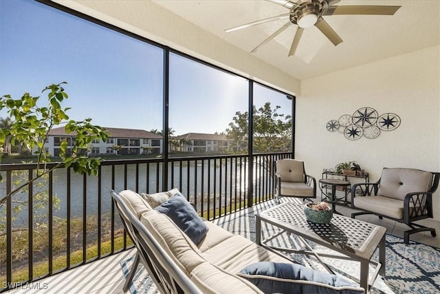 sunroom with a water view and ceiling fan