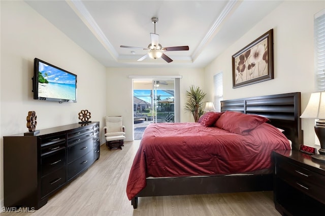 bedroom featuring crown molding, access to outside, a tray ceiling, ceiling fan, and light hardwood / wood-style floors