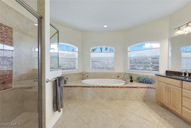 bathroom featuring tile patterned flooring, vanity, and shower with separate bathtub