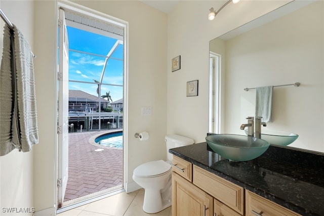 bathroom featuring a water view, tile patterned floors, toilet, and vanity