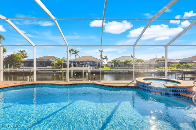 view of pool featuring a water view, glass enclosure, and an in ground hot tub