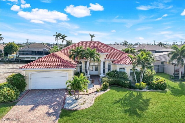 mediterranean / spanish house with a garage and a front lawn