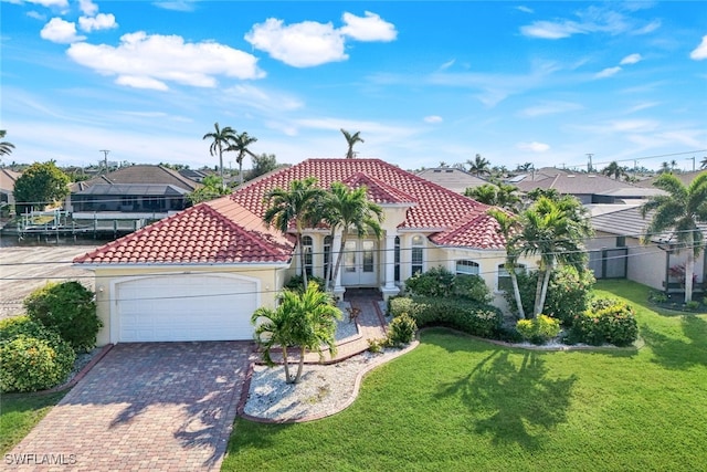 mediterranean / spanish-style house with a garage and a front lawn