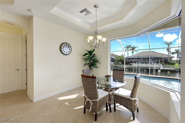 dining space featuring a tray ceiling, a healthy amount of sunlight, and light tile patterned flooring