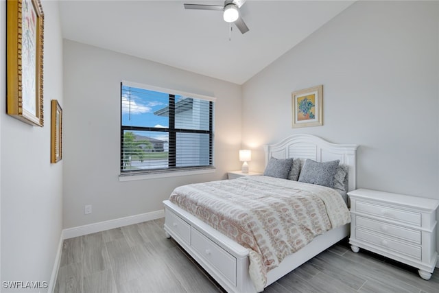 bedroom with ceiling fan, lofted ceiling, and wood-type flooring