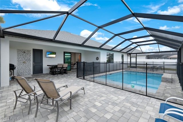 view of swimming pool with a patio area and a lanai