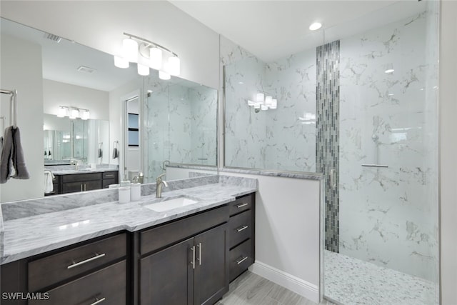 bathroom with a tile shower, hardwood / wood-style floors, and vanity