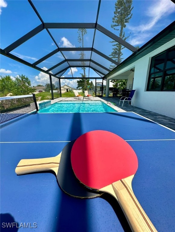 view of pool with glass enclosure and a patio