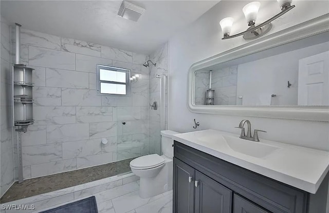 bathroom featuring tiled shower, vanity, and toilet