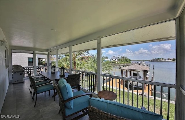 sunroom featuring a water view