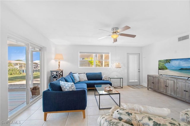 tiled living room with a wealth of natural light and ceiling fan