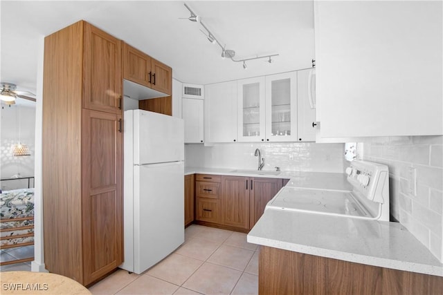 kitchen featuring electric range oven, sink, ceiling fan, white fridge, and white cabinetry