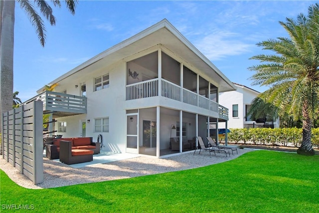 back of property featuring a sunroom, a patio, an outdoor hangout area, and a lawn