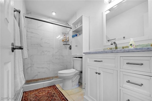 bathroom with tile patterned floors, vanity, an enclosed shower, and toilet