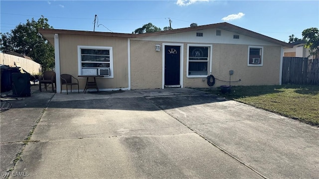 view of front of property featuring fence, a front lawn, and a patio