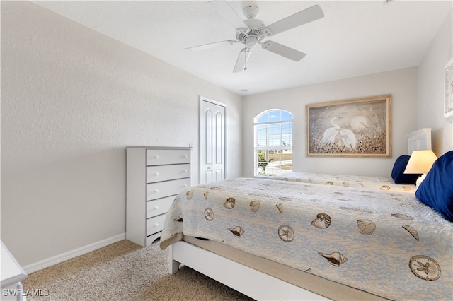 carpeted bedroom with ceiling fan and a closet