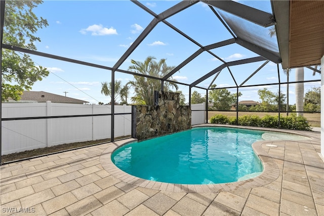 view of pool with glass enclosure and a patio