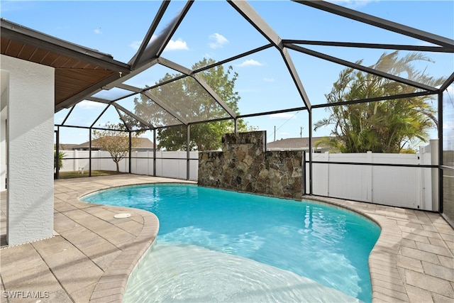 view of pool with a patio area and glass enclosure