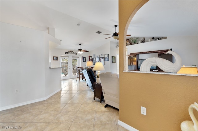 corridor with light tile patterned floors, french doors, and vaulted ceiling