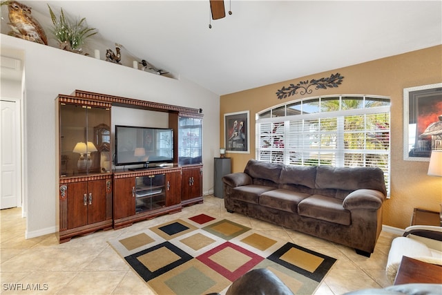 tiled living room with ceiling fan and lofted ceiling