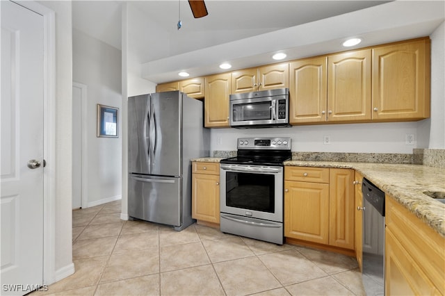 kitchen with ceiling fan, appliances with stainless steel finishes, light tile patterned floors, light brown cabinetry, and light stone counters