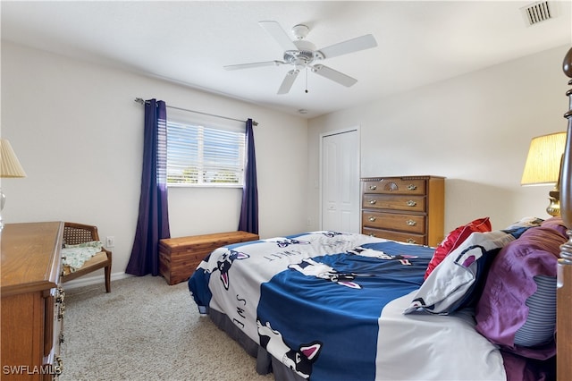 carpeted bedroom with ceiling fan and a closet