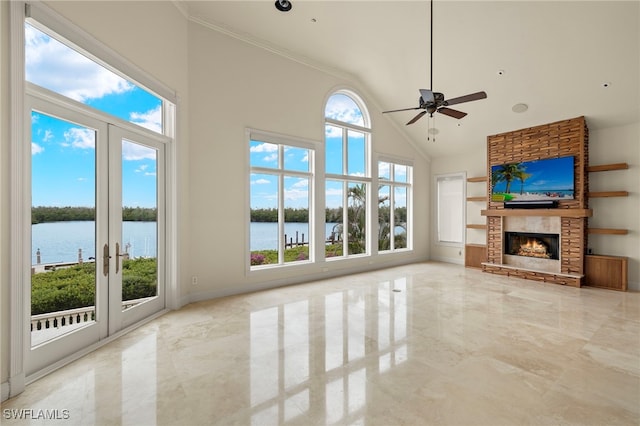 unfurnished living room featuring a stone fireplace, marble finish floor, high vaulted ceiling, and plenty of natural light