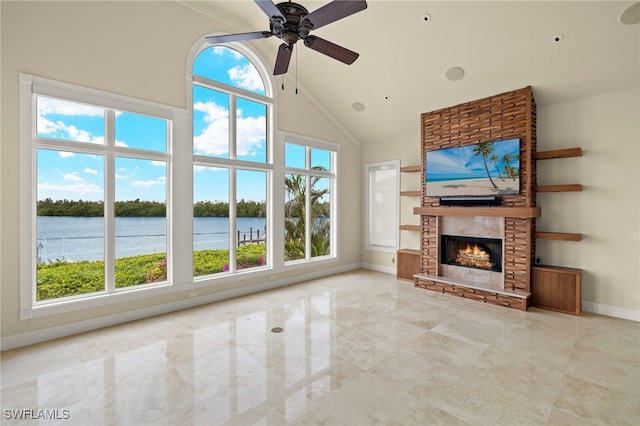 unfurnished living room featuring high vaulted ceiling, marble finish floor, a ceiling fan, a fireplace, and baseboards