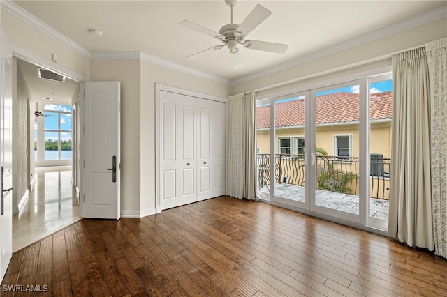 unfurnished bedroom featuring visible vents, ornamental molding, hardwood / wood-style floors, a closet, and access to exterior