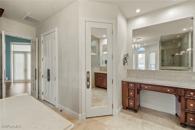 bathroom featuring walk in shower, vanity, a notable chandelier, tile patterned floors, and decorative backsplash