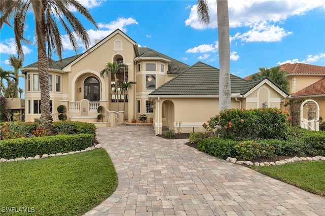 view of front of house with stucco siding, french doors, and a tiled roof