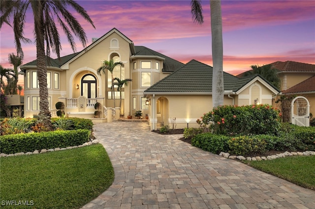 view of front facade featuring a tiled roof, french doors, and stucco siding