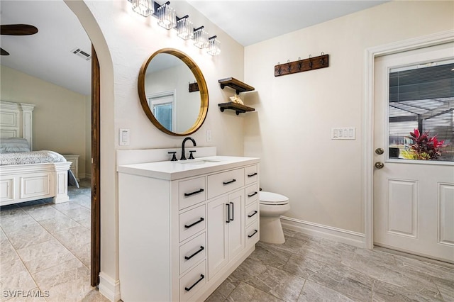 bathroom with ceiling fan, vanity, toilet, and lofted ceiling