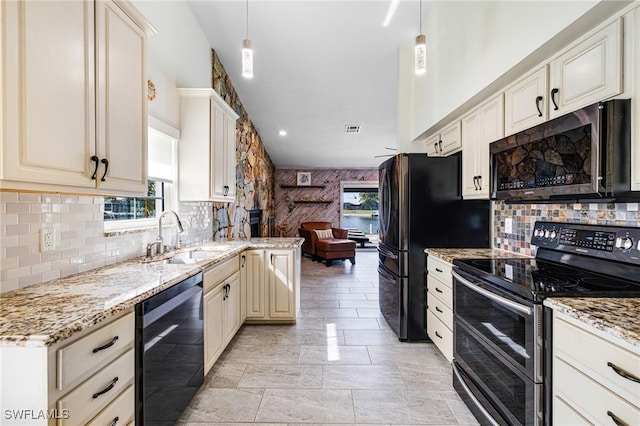 kitchen with hanging light fixtures, cream cabinets, black appliances, and sink